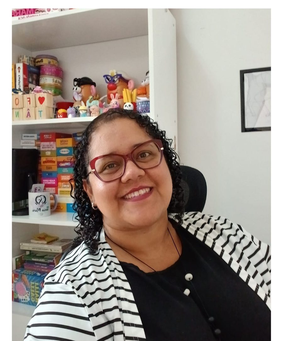 Tânia Mara, fonoaudióloga, sorrindo em seu consultório